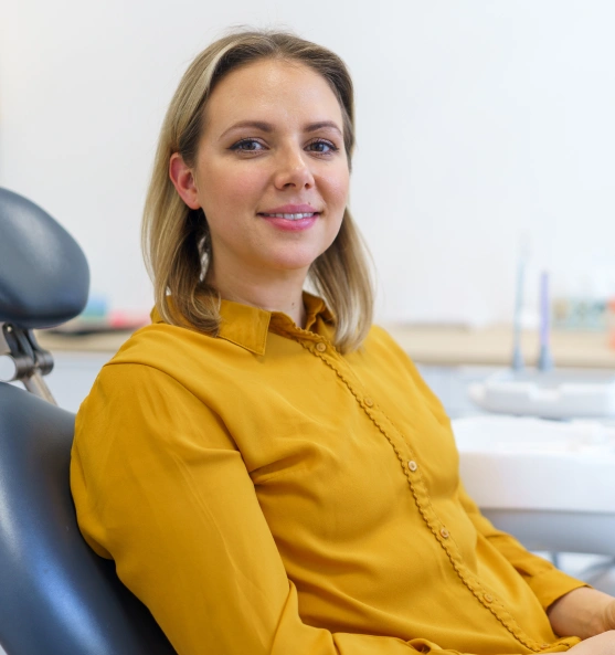 Woman wearing a yellow top and sitting in a dental chair